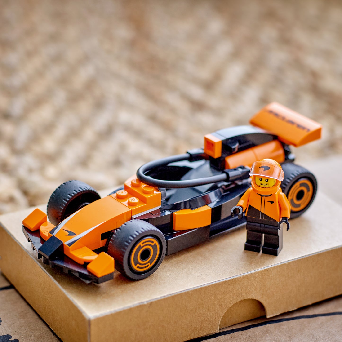 LEGO City F1® Driver with McLaren Race Car set and the assembled orange and black race car model with a minifig driver.