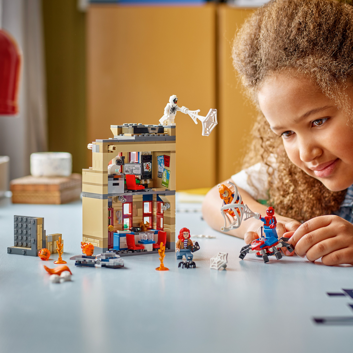 Child playing with LEGO Marvel Spider-Man Peter Parker's Apartment set, on table