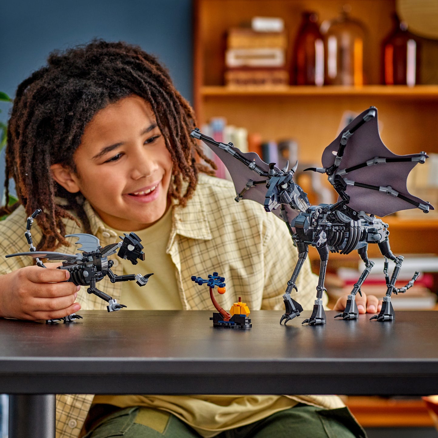Child playing with LEGO Thestral Family set on a table