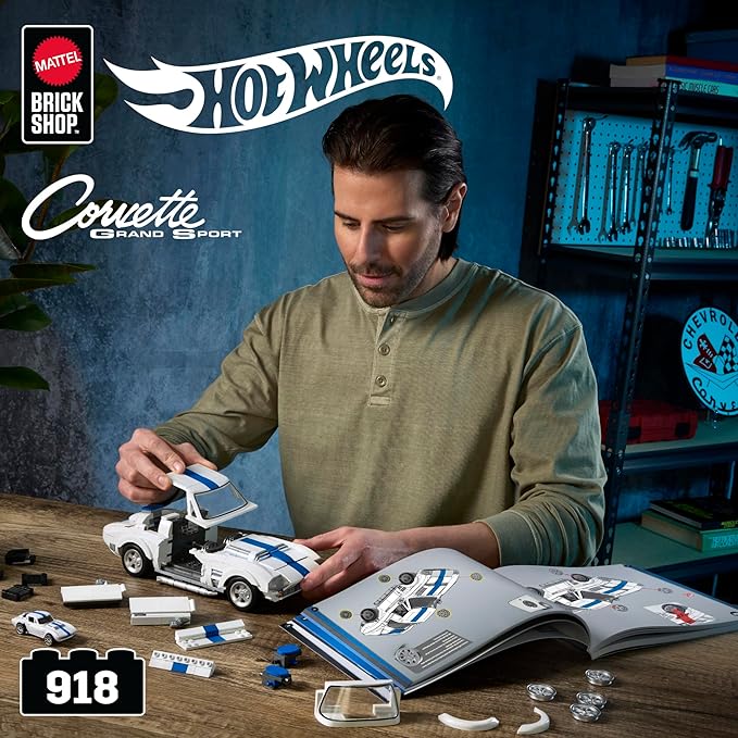 Man assembling a Hot Wheels Corvette Grand Sport toy car set with tools and parts on a workbench.
