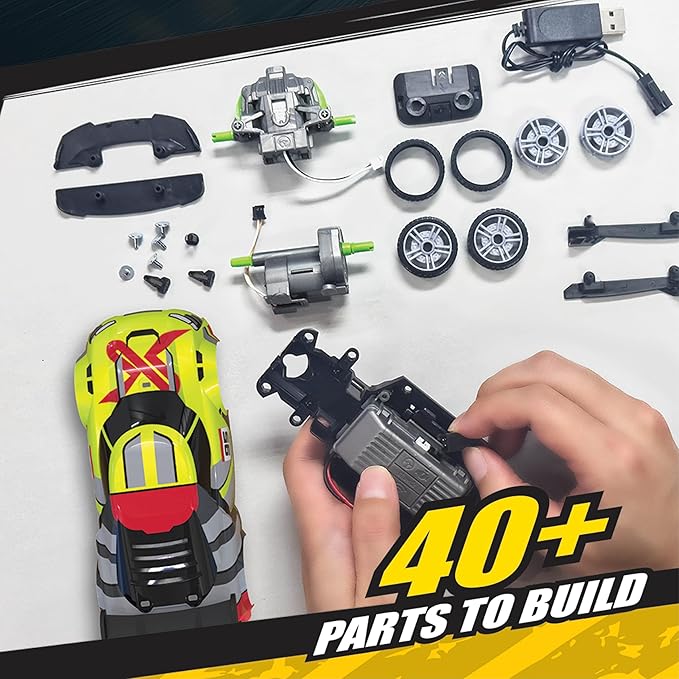 Model building kit with various parts on a white surface, including a hand holding a component.