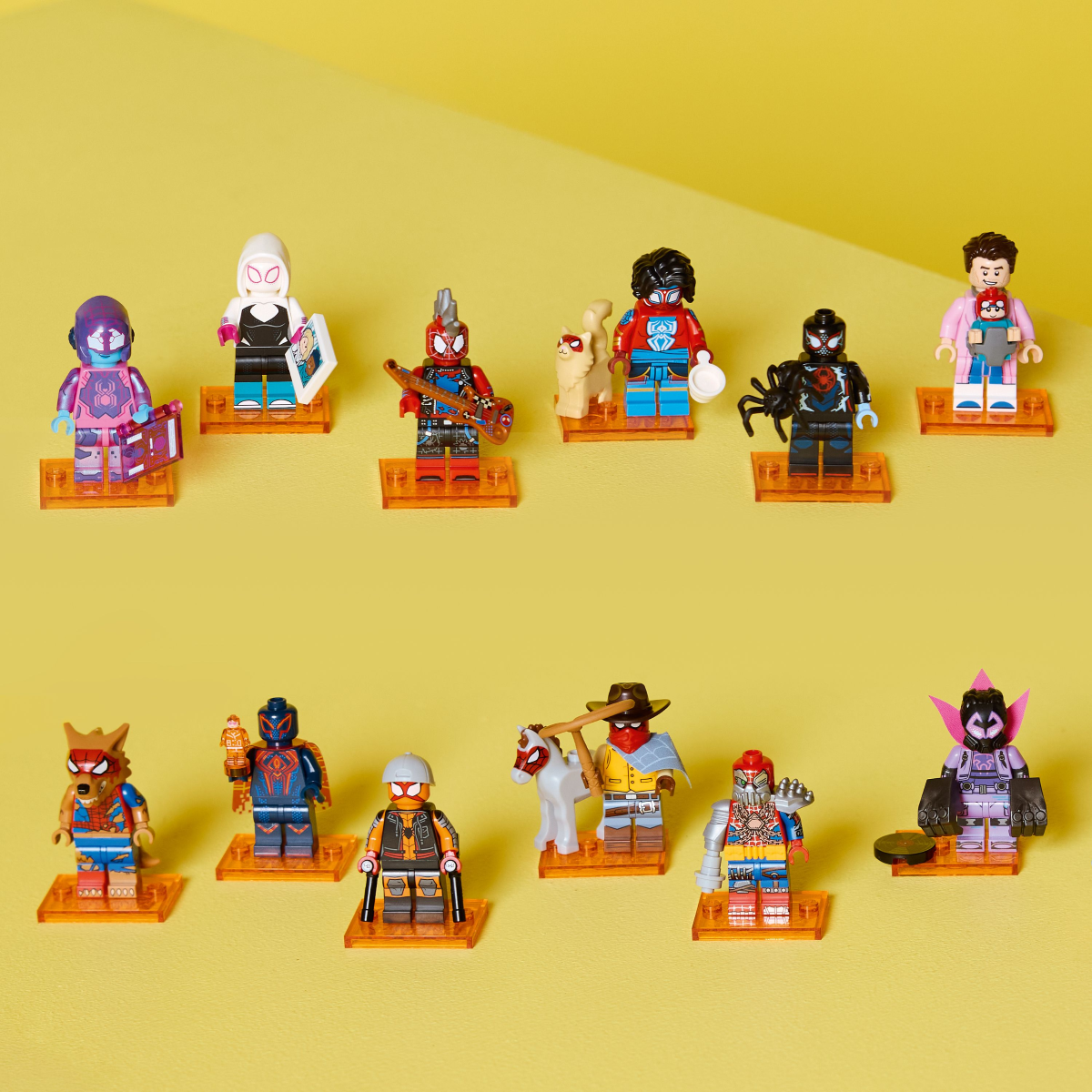 Collection of colorful LEGO spiderman minifigures on a yellow background
