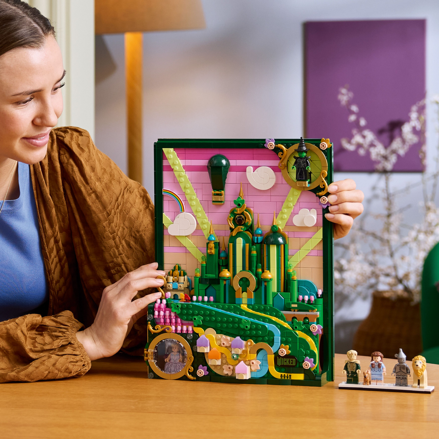 Woman holding the LEGO Wicked Emerald City Wall Art set 