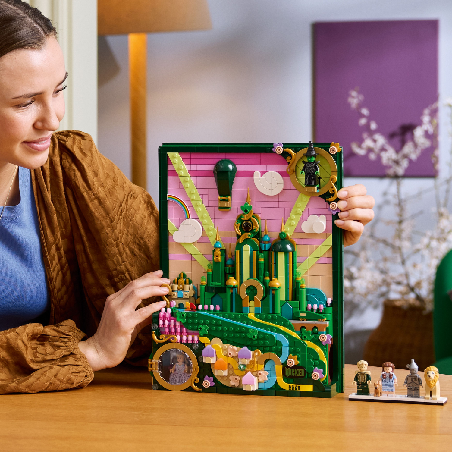 Woman holding the LEGO Wicked Emerald City Wall Art set 