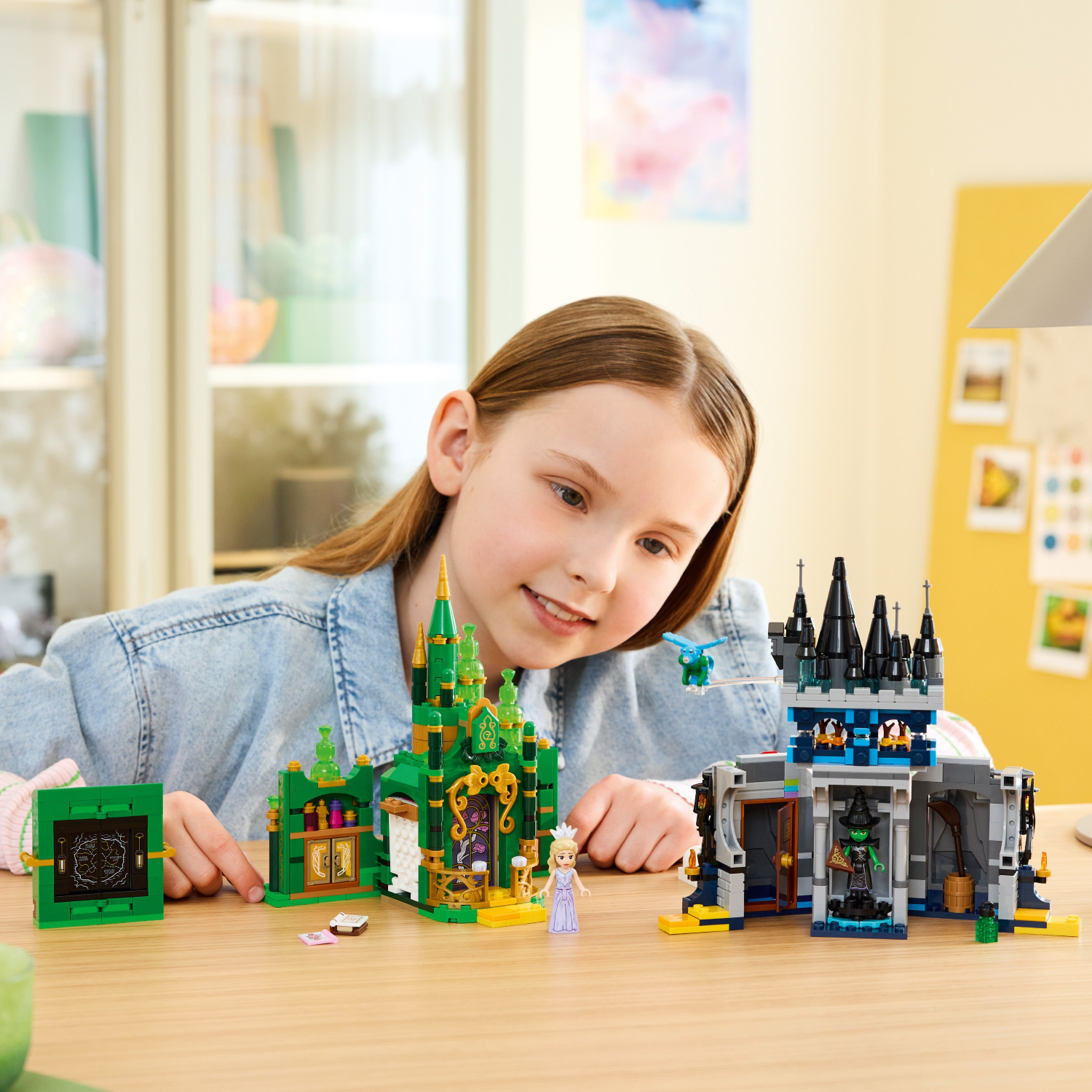 Young girl playing with toy castle sets on a table