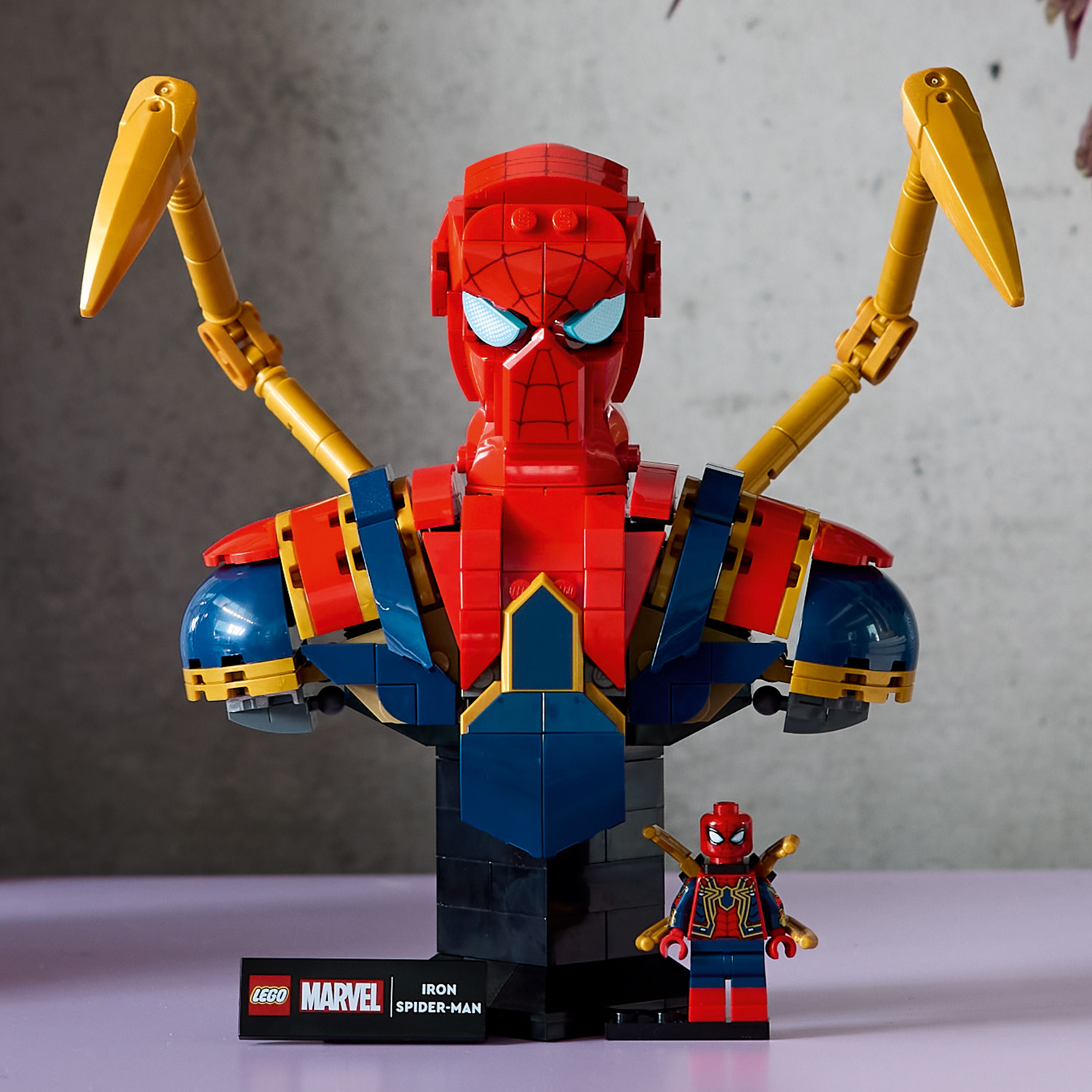LEGO Iron Spider-Man figure with a smaller figure on a gray background.