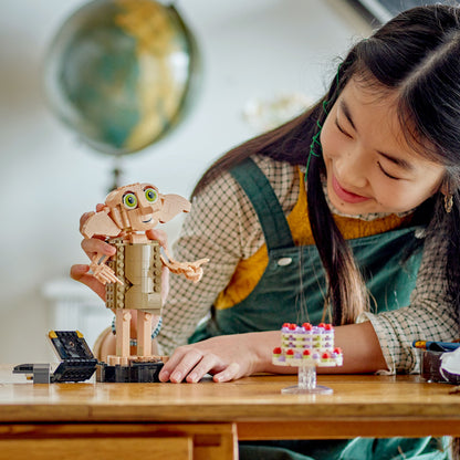 Child playing with LEGO Dobby the House Elf set with cake 