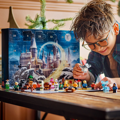 Child playing with LEGO Harry Potter Advent Calendar, with all 24 gifts, on a wooden table.